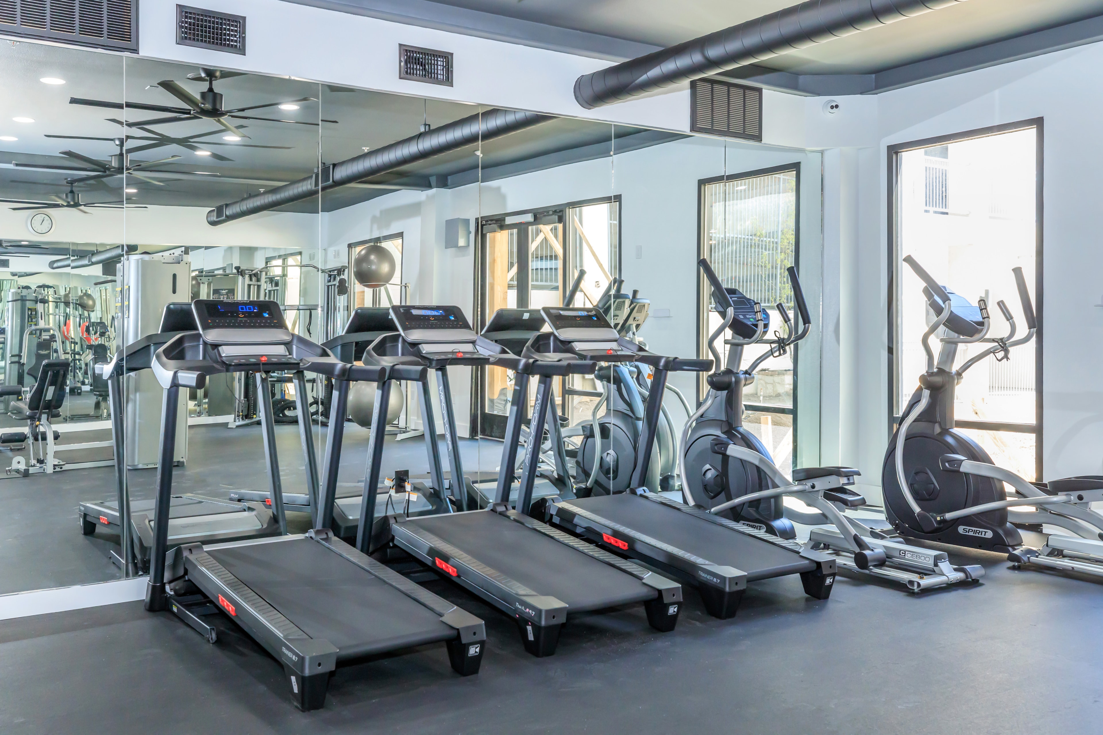 Fitness center with treadmills, ellipticals, and mirrored walls