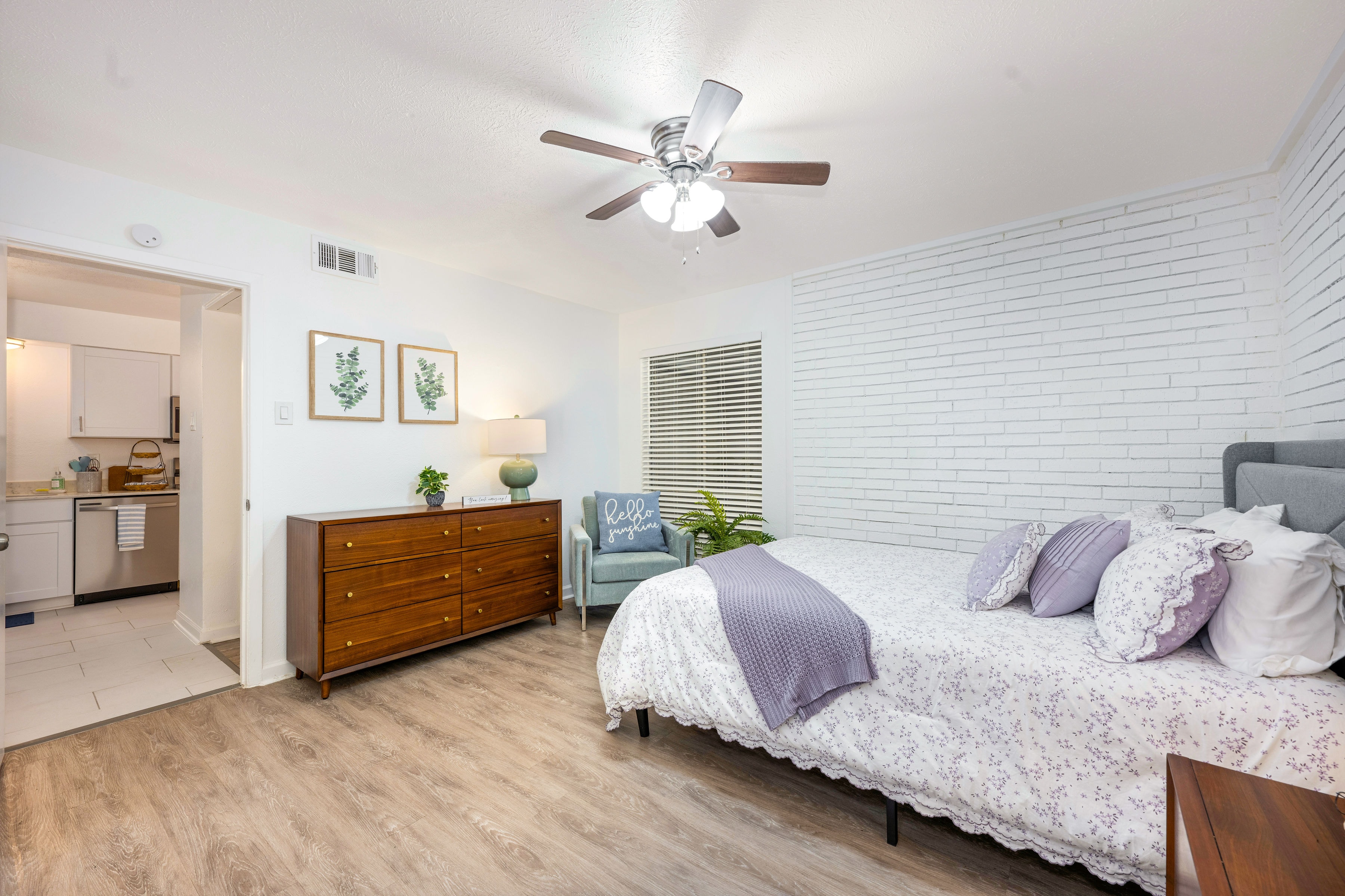 Bedroom with white brick accent wall and queen bed