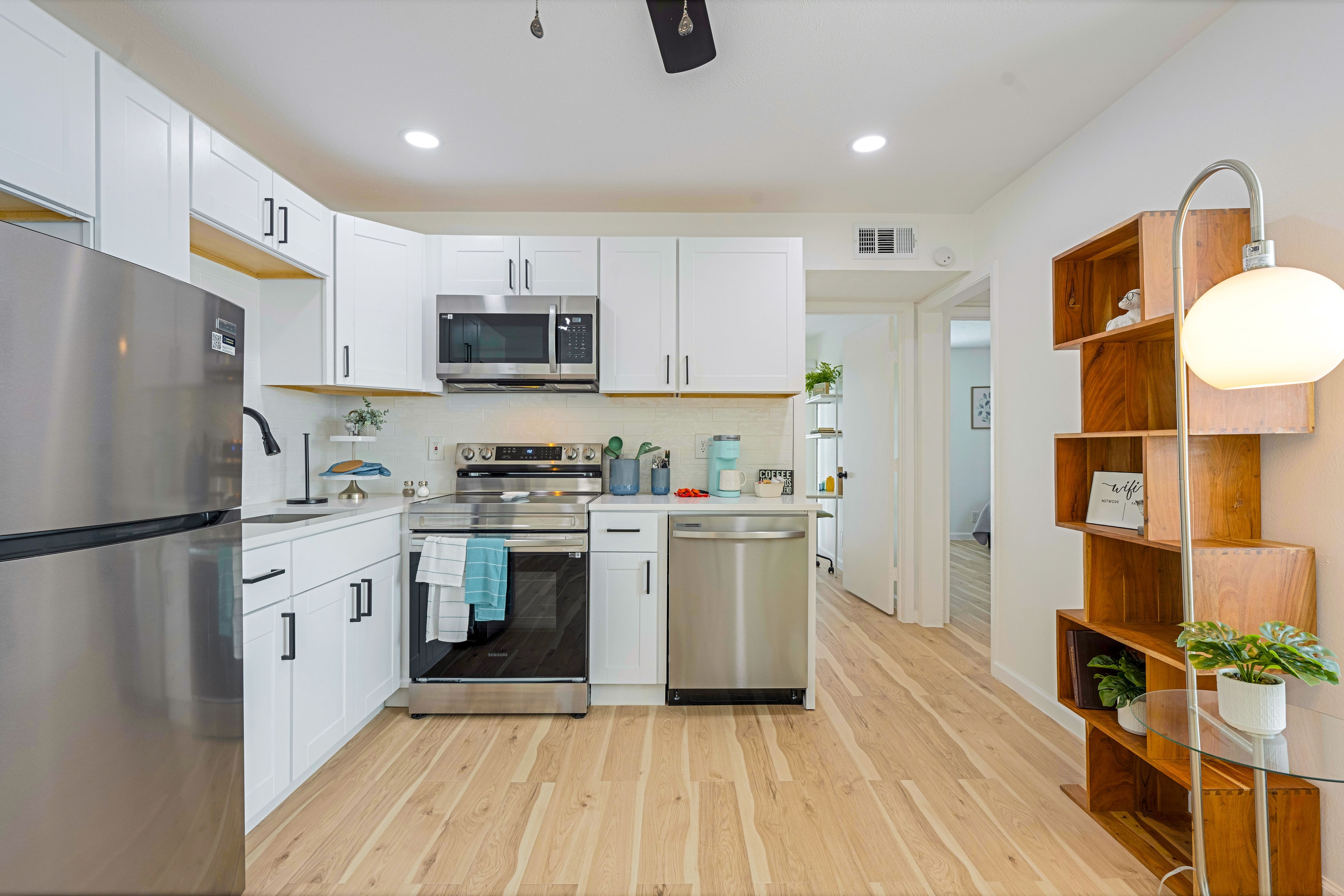 Modern kitchen with white shaker cabinets and light wood floors