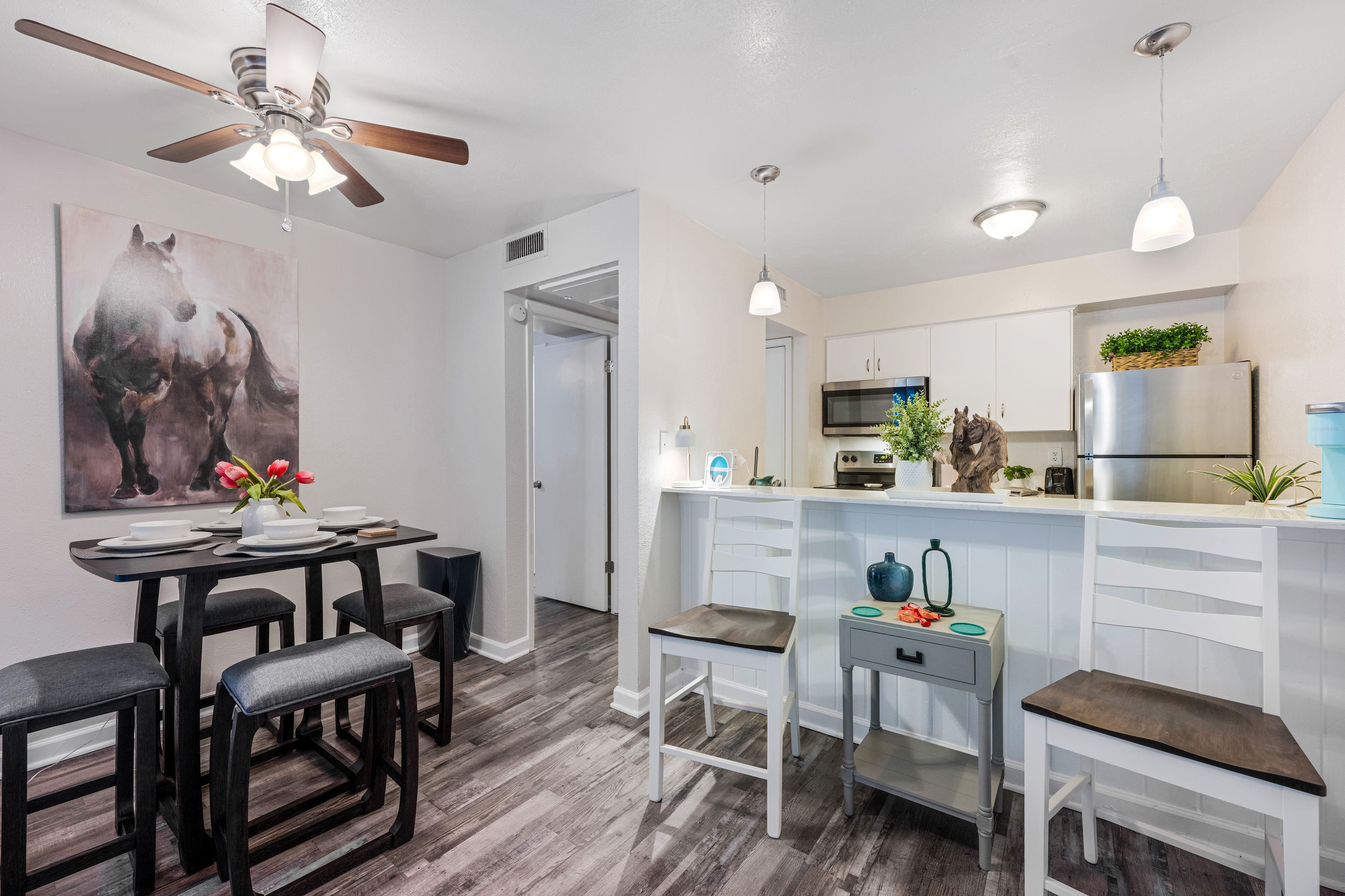 Dining area with kitchen and horse artwork