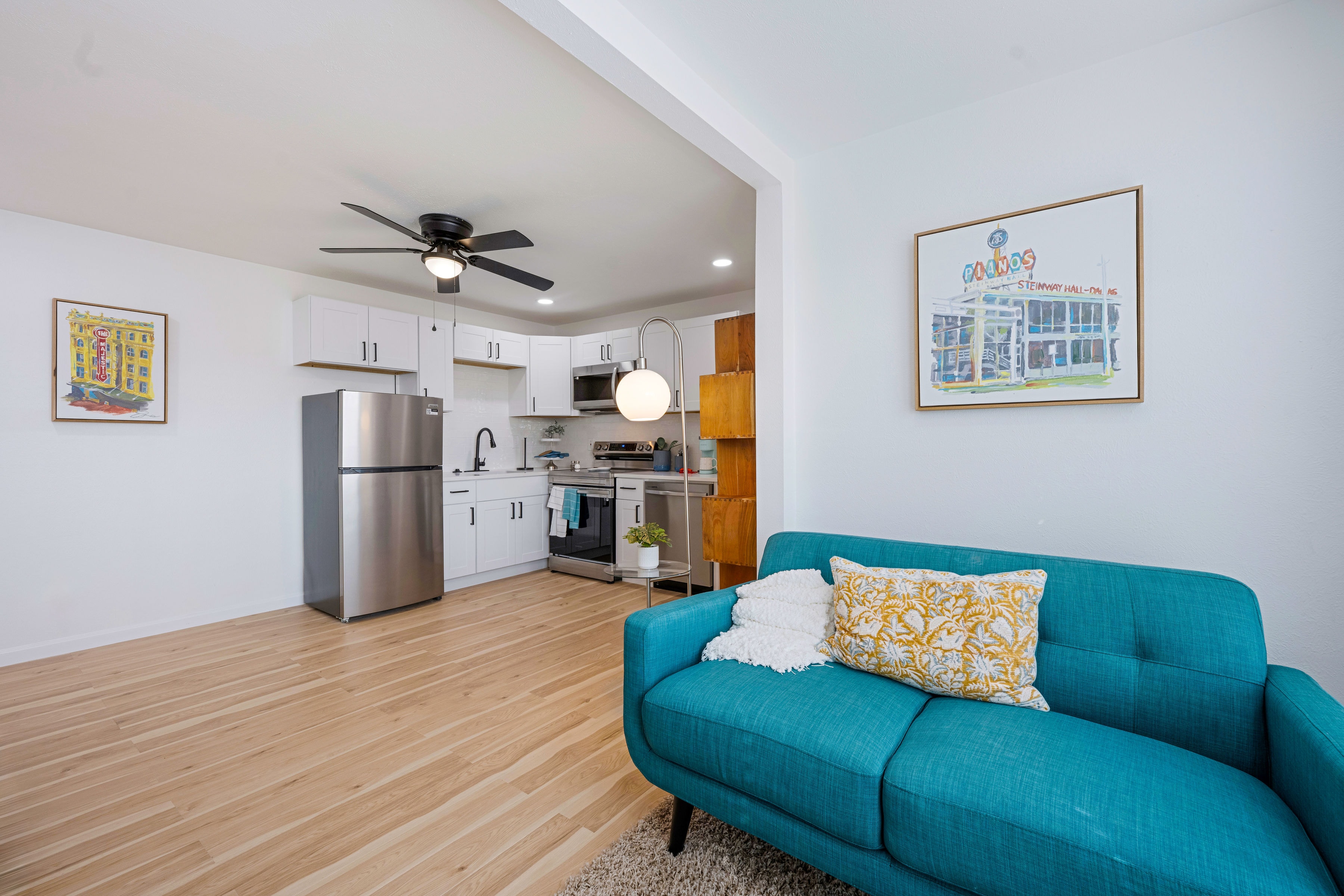 Living room with teal sofa and open kitchen view