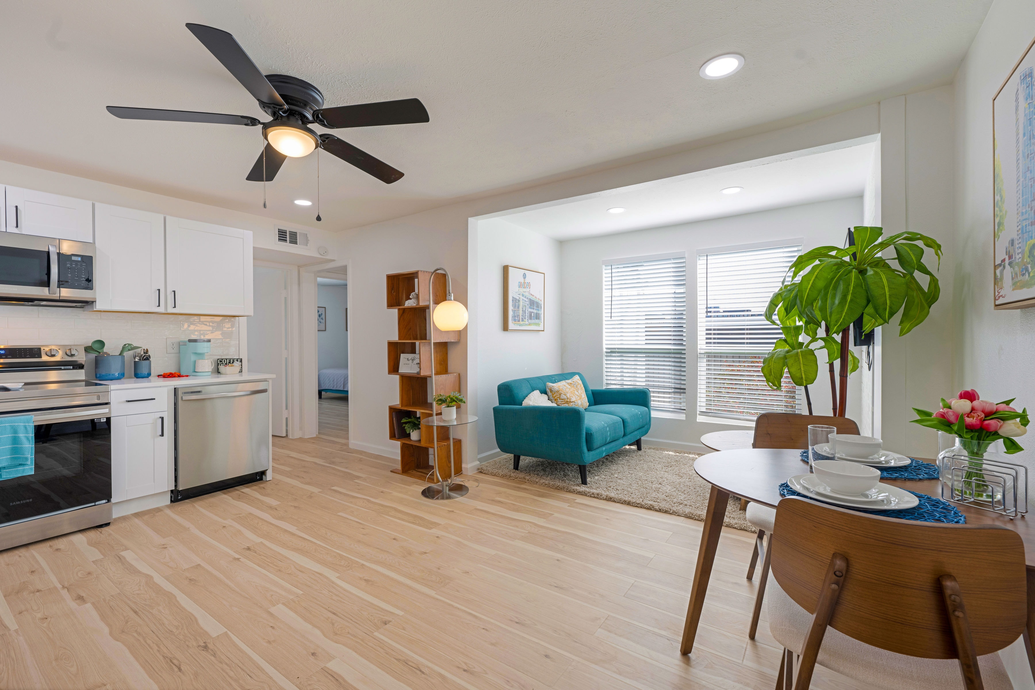 Open-concept kitchen and living room with teal sofa
