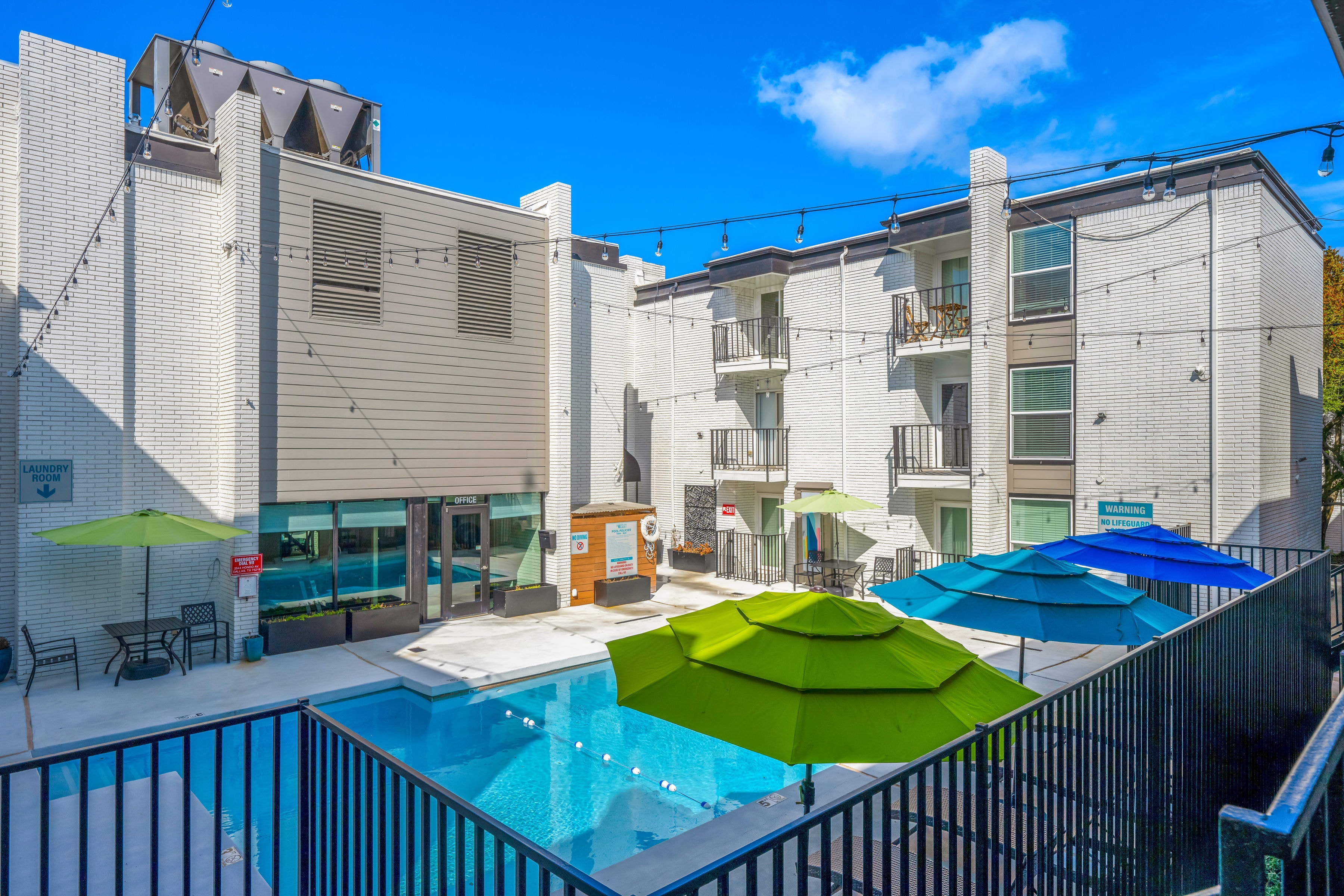 Aerial view of pool courtyard with green and blue umbrellas